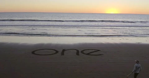Man walking into the word one on the beach Video stock 58649432