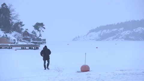 Man walks across frozen lake Stock Footage