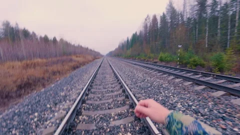 A man walks along a double-track railway.Railway tracks. From the first person. Stock Footage 320386381