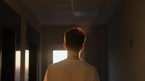 A man walks along the hospital corridor towards the exit at sunset Stock Footage 277945053