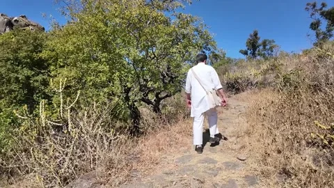A man walks along a mountain path on a sunny day Stock-Footage 307219764
