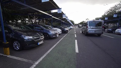 A man walks along the street parking of the airport to a car rental. The guy Vídeos de archivo 115702853