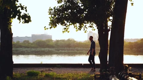 A man walks along the trees and stops at sunset, side view Stock Footage 156726558