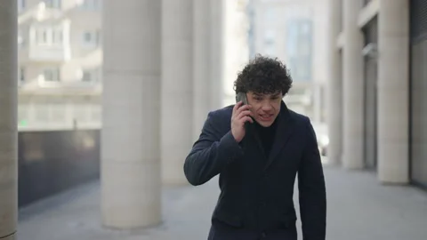 A man walks and talks on a mobile phone, swears, freaks out, gets angry, yells. Stockbeeldmateriaal 200143231