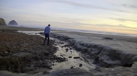Man walks around an ocean stream Stock Footage 59902007