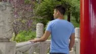 Man Walks Around Pagoda, Touching Stonework As He Goes (Slow Motion) Stock Footage