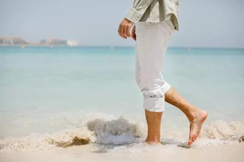 A man walks on the background of a beautiful white sand beach Foto stock