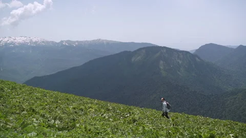 A man walks with a backpack on the background of a beautiful mountain landscape. Stock Footage 152539892