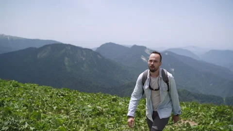 A man walks with a backpack on the background of a beautiful mountain landscape. Stock Footage 152540208