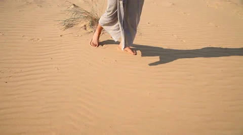Man walks barefoot through the desert Видео 67514541