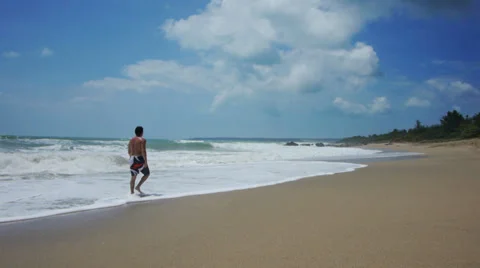 Man walks on beach Stock Footage 32225030