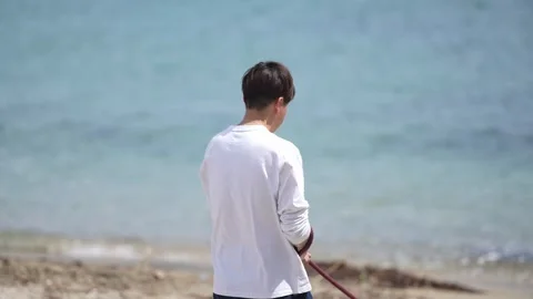 Man walks beach, hand holding leash Stock Footage 339982596