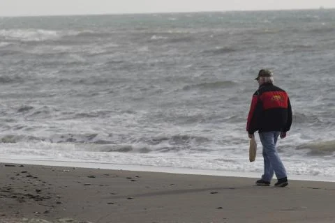 Man walks on the beach one winter morning, alone Stock Photos