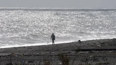 A man walks on the beach with strong wind Video stock 97818807