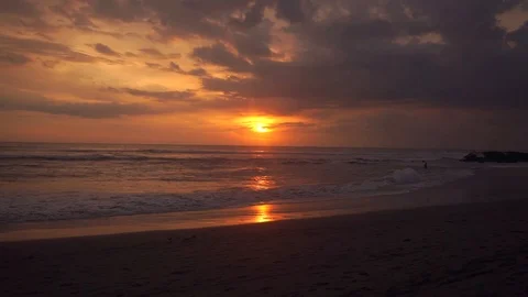 Man walks the beach at sunset Stock Footage 109119441