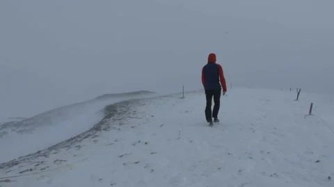 A man walks in a blizzard, storm through the snow. Strong wind and snow Stock Footage 227904470