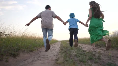 A man walks with a boy on the dirt path as the woman leads them. The woman Video stock 316038216