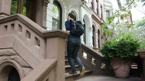 Man walks up brownstone stoop 스톡 동영상 25682347