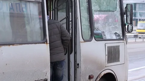 A man walks into a bus at the bus stop Stock Footage 72985329