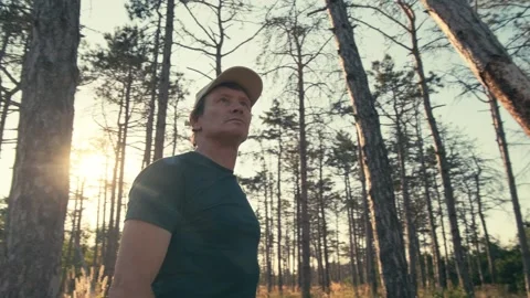 Man walks in circles in the forest and looks up somewhere 動画素材 345992856