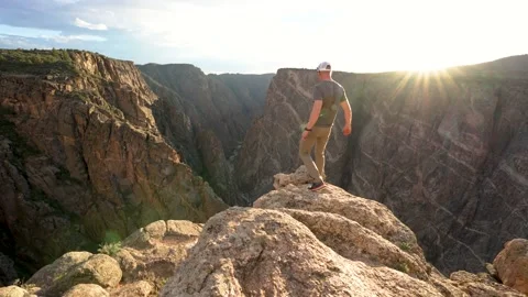 Man walks to Cliff Ledge at Sunset | Black Canyon of the Gunnison | 4k Footage Video stock 209330501