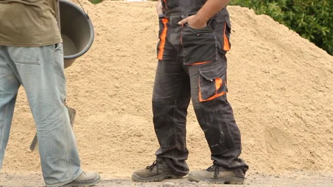 A man walks up to a construction worker and hands him a shovel Stock Footage 254823526