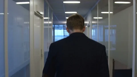 Man walks in the corridor at his workplace Stock Footage 75492077