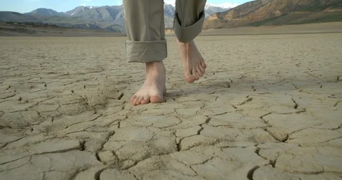 A man walks on cracked ground Stock Footage 126993863