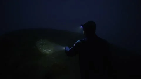 A man walks in the dark with a flashlight. Search works, fog. Mysticism Stock Footage 238427235