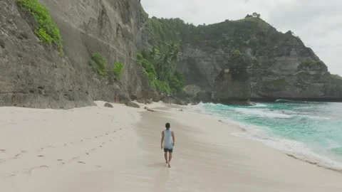 A man walks on Diamond Beach or Atuh Beach in Bali Video stock 267677985