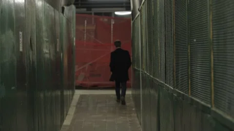 Man walks down construction scaffolding tunnel in New York City at night Stock Footage 241498878