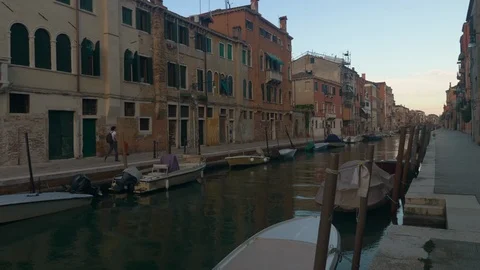 Man walks down lonely Venice street Stock Footage 96773574