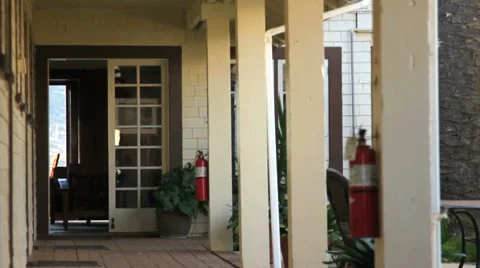 MAN WALKS DOWN LONG BREEZEWAY Stock Footage 8575306