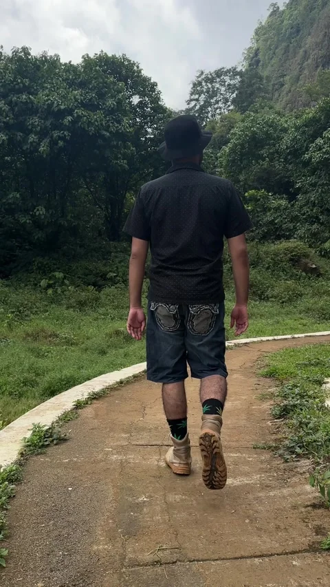 Man Walks Down Paved Path in Green Mountain Forest Vertical Stock Footage 323912661