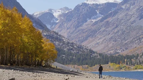 Man walks down river bed with distant mountains Stock Footage 74090507