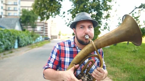 A man walks down the road and plays the trumpet Stock Footage 221443551