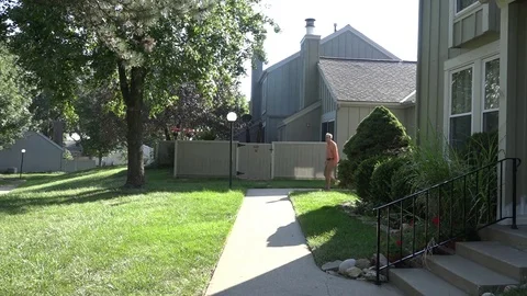 A Man Walks Down Sidewalk, Arrives Home and Climbs Front Steps Stock-Footage 79111021