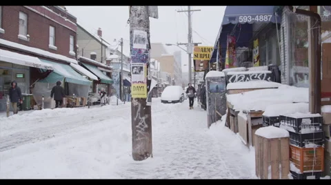 Man walks down sidewalk of snowy marketplace Stock Footage 57096067