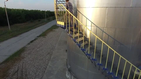 A man walks down the stairs next to the tank for chemicals, aerial view Stock Footage 86863487