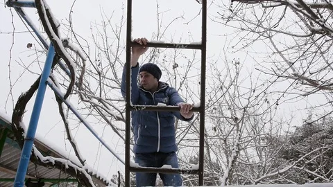 A man walks down the stairs in the winter from the attic of the house Stock Footage 72682305