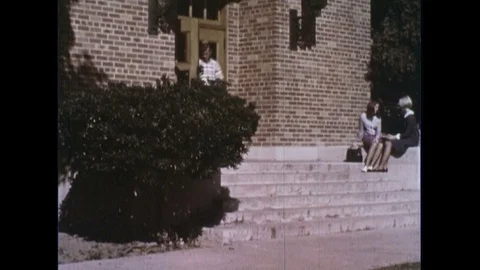 A man walks down the steps of a building in his school an receives a D on a Vídeos de archivo 74500079