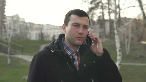 Man walks down the street and speaks on the phone Stock Footage 128104953