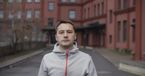 A man walks down the street, is engaged in a warm-up before running. Close-up Stock Footage 120772390