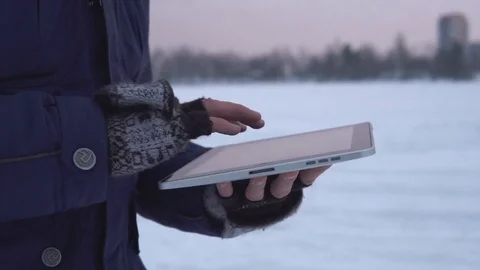 Man Walks Down the Street in Winter and Uses a Tablet Stock Footage 83709477