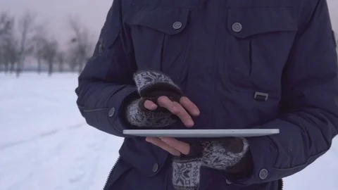 Man Walks Down the Street in Winter and Uses a Tablet Stock Footage 83709486