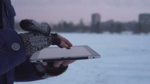 Man Walks Down the Street in Winter and Uses a Tablet Stock Footage 83709599