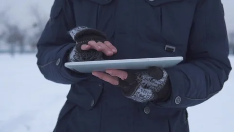 Man Walks Down the Street in Winter and Uses a Tablet Stock Footage 83709647