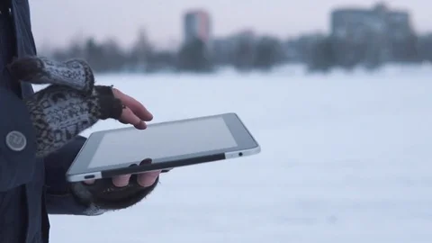 Man Walks Down the Street in Winter and Uses a Tablet Stock Footage 83709650