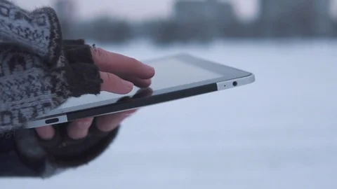 Man Walks Down the Street in Winter and Uses a Tablet Stock Footage 83709677