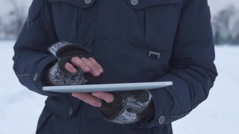 Man Walks Down the Street in Winter and Uses a Tablet Stock Footage 83709752